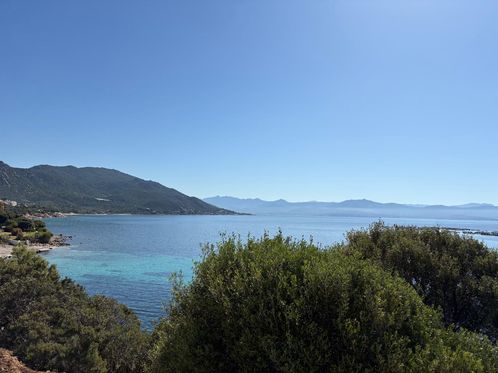 Mountainous coastline beside calm turquoise water
