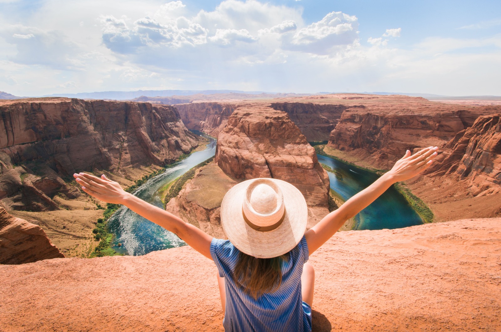 Traveller overlooking a red-rock canyon and winding river